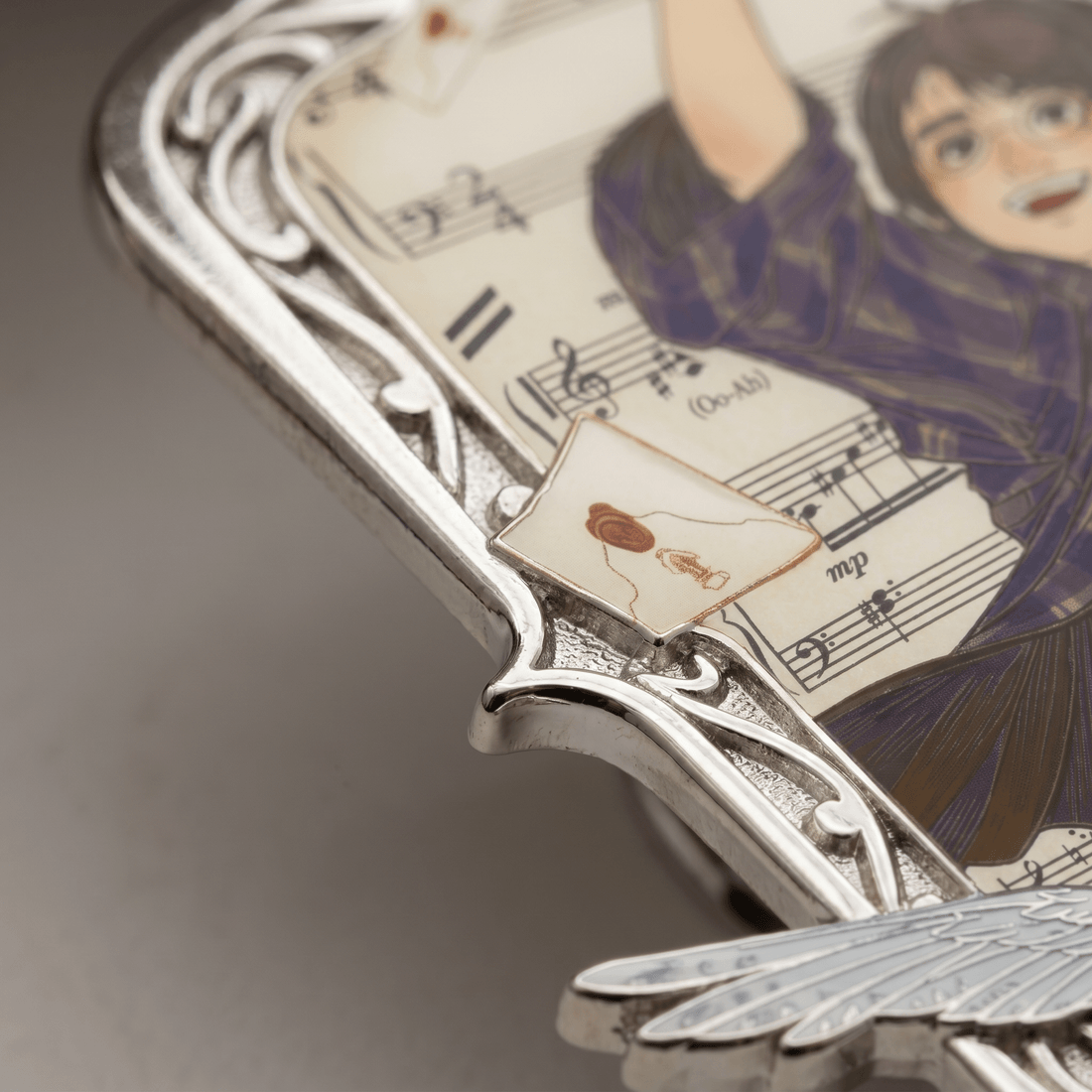 Macro: the printed score of Hedwig's Theme behind the silverwork